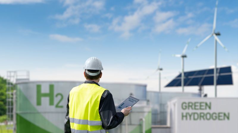 Arbeiter mit Tablet vor Wasserstoff-Technologien