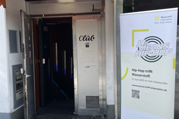 Das Bild zeigt den Eingang zum Club Subway in Köln und ein davorstehendes Rollup des Hip-Hop-Events.