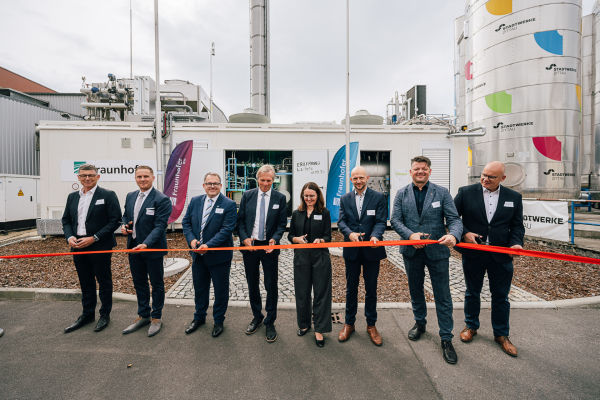 Projektpartner sowie Vertreter:innen der Politik und der Stadtwerke Zittau zerschneiden gemeinsam ein Band zur Eröffnung der Laboranlage.